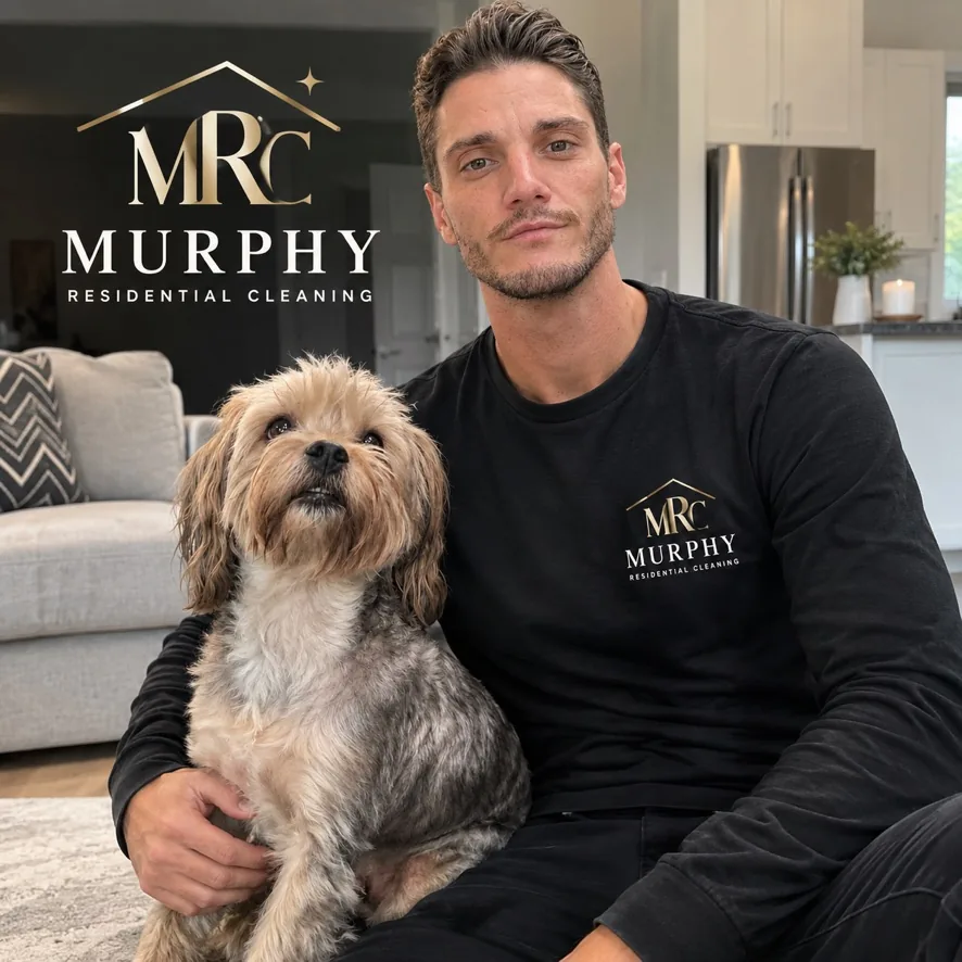 Cole, founder of Murphy Residential Cleaning, sitting on a living room floor with his dog Murphy